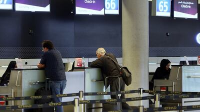 Passengers at Abu Dhabi International Airport check on their Etihad Airways flight. Delores Johnson / The National