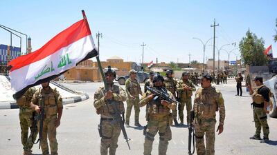 Iraqi government forces celebrate with national flags on a street on May 19, 2016 in the western town of Rutba after they recaptured it from ISIL. Rutba, located in western Anbar province along the main road to Jordan, had been held by ISIL since 2014. Moadh Al Dulaimi/AFP
