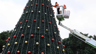 A municipality worker decorates the Christmas tree in Manger Square. AFP