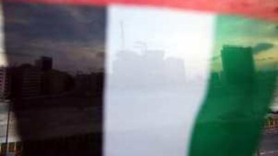A Dubai construction site is seen behind the flag of the UAE, the emirate has seen rapid development in recent years.