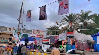Protesters have lunch near pictures of protesters who have been killed in anti-government demonstrations in Baghdad, Iraq. AP Photo