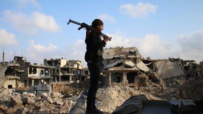 A rebel fighter stands amid the rubble of destroyed buildings in the rebel-held area of Daraa in southern Syria. Mohamad Abazeed / AFP Photo