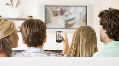 Family in living room with remote control and flat screen television (iStockphoto.com)