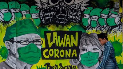 A man walks past a mural depicting the COVID-19 coronavirus in Bangkalan, east Java. AFP