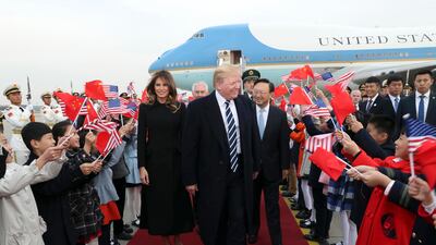 Children wave US and Chinese flags as US president Donald Trump and first lady Melania Trump arrive at Beijing Airport. Pang Xinglei / Xinhua via AP