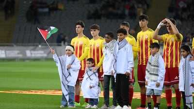 Palestinian mascots line up on the pitch next to players ahead of the friendly between Catalonia and Palestine. Getty Images
