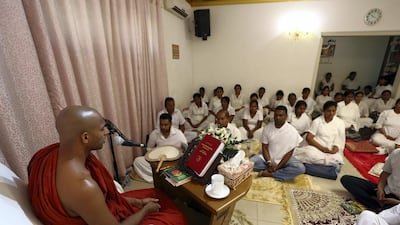 Worshippers hear the chanting of the Buddhist monk at the temple in Dubai. Chris Whiteoak / The National