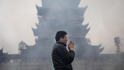 A man worships the God of Fortune at the Guiyuan Temple in Wuhan, Hubei province, China. Wang He / Getty Images