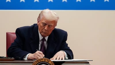 US President Donald Trump signs an executive order on his first day back in office, in Washington. Bloomberg