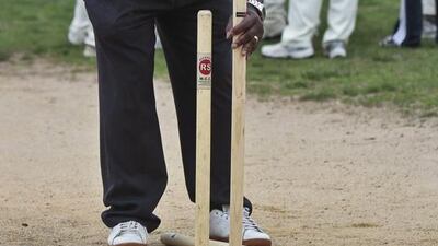 In this May 12, 2014 photo, cricket umpire Carl Whatley uses a hammer to set up wickets for a New York City Public School Athletic League (PSAL) cricket match between John Adams and Midwood high schools. Bebeto Matthews / AP