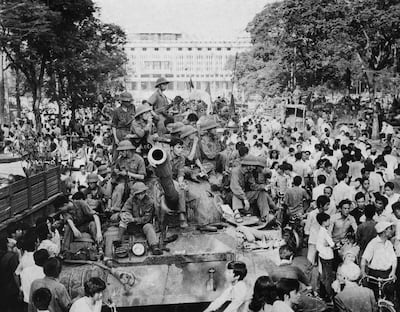 Local residents crowd North Vietnamese Army tanks taking position near the presidential palace in Saigon, following a last ditch battle, on on April 30, 1975. AFP