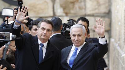 Brazilian President Jair Bolsonaro (L) and Israeli Prime Minister Benjamin Netanyahu wave to the press during a visit to the Western wall, the holiest site where Jews can pray, in the Old City of Jerusalem on April 1, 2019. AFP