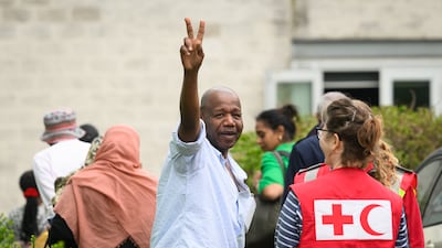 A V sign for victory as people rescued from Sudan arrive at Stansted Airport in south-east England. Getty Images