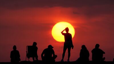 People turn out to watch the sunrise on Tuesday morning at Cullercoats Bay, North Tyneside. PA