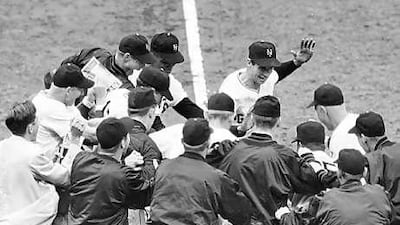 The New York Giants baseball team greet teammate Bobby Thomson, centre rear with hand raised, after Thomson's ninth-inning homer against the Brooklyn Dodgers in this October 3, 1951, file photo.