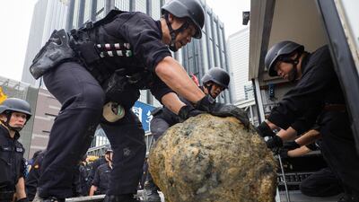 Members of the explosive ordinance disposal unit load a defused US-made bomb (C), dropped during World War II, into a lorry a day after it was found inside a construction site. Hundreds of people were evacuated after the ordnance was found. Anthony Wallace / AFP
