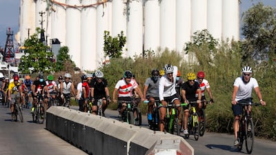 Former American professional cyclist Lance Armstrong, right, rides with Lebanese and foreign cyclists at the site of the August 4 deadly blast in the port of Beirut that killed scores and wounded thousands in Beirut. AP