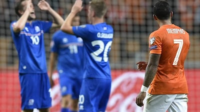 Iceland players celebrate victory in Amsterdam as Netherlands forward Memphis Depay, right, looks on. Iceland won 1-0. John Thys / AFP