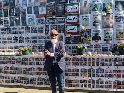Ahad Ghanbary, an Iranian community advocate, beside the memorial wall in north west London where police are investigating a suspected arson attack. PA