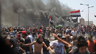 Iraqi protesters run for cover as they clash with security forces on Al Jumhuriyah in the capital Baghdad, following an anti-government demonstration. AFP