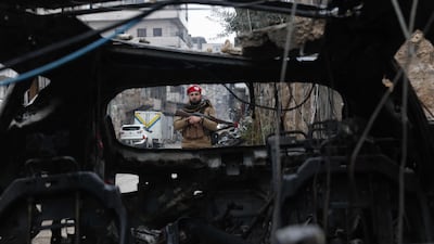 A Syrian security officer looks at a destroyed vehicle in the Sheikh Maqsoud neighbourhood of Aleppo. AFP