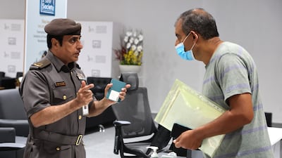A UAE official guides an amnesty seeker about the opportunity to cancel overstay visa fines and return home or remain in the UAE if they find a job