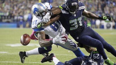 Seattle Seahawks safety Kam Chancellor, right, knocks the ball loose from Detroit Lions wide receiver Calvin Johnson in Seattle's 13-10 NFL victory on Monday night. Elaine Thompson / AP / October 5, 2015