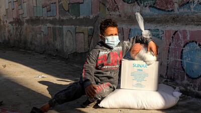 A masked child sits next to packs of humanitarian aid in Gaza City. The Covid-19 crisis has profoundly affected employment in an already faltering Palestinian economy, the World Bank said. AFP