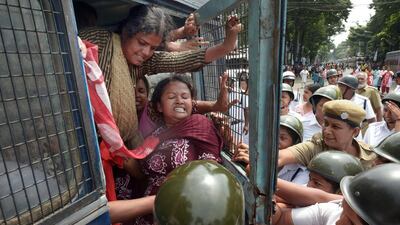 Indian police try to close the gate of a police van as arrested trade union activists try to force it open during a protest in Kolkata on September 2, 2015. Millions of workers across India held a 24-hour strike in protest at right-wing prime minister Narendra Modi's economic policies, which they say will put jobs at risk and hurt ordinary people. Dibyangshu Sarkar/AFP Photo