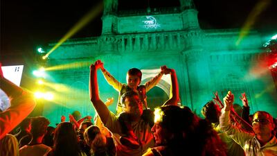 This combination photograph shows a handful of people in front of the iconic Gateway of India, top, a popular place to celebrate New Year's Eve in Mumbai, India, Thursday, Dec. 31, 2020, as compared to a file photograph of a crowd celebrating on Dec. 31, 2019. AP Photo