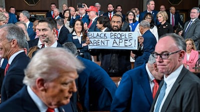 Texas Democrat Representative Al Green holds up a sign as Mr Trump passes on his way to deliver the State of the Union address. AFP
