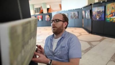 Sam Faix help helps put together an art expiation at the National Theater in Abu Dhabi.