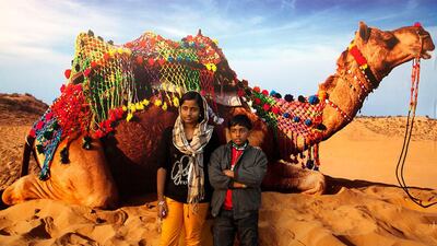 Visitors at Global Village pose for a portrait infront of a photo advertisement from India.