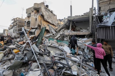 People inspect damage and recover items from their destroyed homes after Israeli air strikes on Rafah on Monday. Getty Images