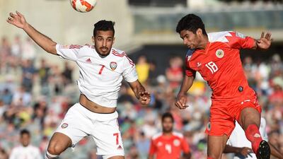 UAE striker Ali Mabkhout, left, attempts an ariel challenge against Mohamed Mahorfi.