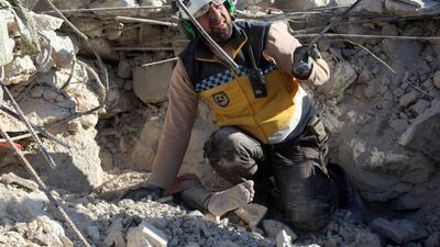 A member of the Syrian Civil Defence prepares to help remove the body of a woman burried under the rubble of a building in Rakaya Sijneh, Idlib. AFP