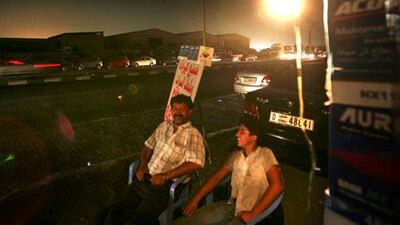 People in Sharjah use car batteries to power outdoor lighting after an electricity failure in the area in August, 2009.