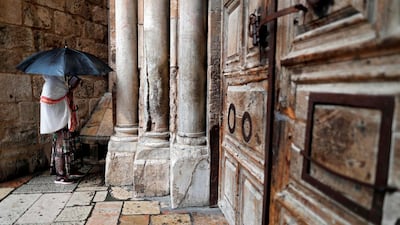 A Christian woman prays by the closed door of the main entrance of the Church of the Holy Sepulchre in the Old City of Jerusalem on February 26, 2018. Thomas Coex / AFP