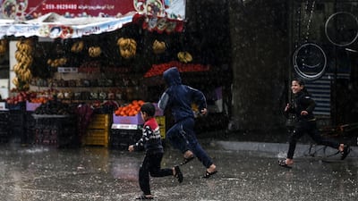 Children run in flooded street on a rainy day in al-Amal (hope in Arabic) neighbourhood of Beit Lahia in the northern Gaza Strip. AFP