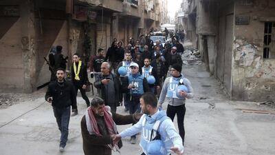 UN members walk along a street at the Palestinian refugee camp of Yarmouk, in southern Damascus. Reuters (24 February)