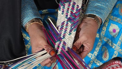 An Emirati woman weaves a basket at the Tan-Tan Moussem Festival in Morocco. Courtesy TCA