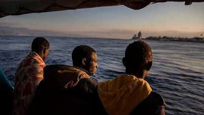 Men who were rescued off the Libyan coast on Friday, watch the city of Messina from the deck of the Open Arms rescue vessel. AP