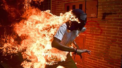 Ronaldo Schemidt won Picture of the Year 2018 for this shot which shows demonstrator Jose Victor Salazar Balza catching fire during clashes with riot police at a protest against Venezuelan President Nicolas Maduro, in Caracas, Venezuela. EPA/RONALDO SCHEMIDT/AFP