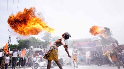 Revellers perform a fire-breathing stunt as they take part in a religious procession during the 'Kanwar Yatra' pilgrimage in the sacred month of Shravan, in Ajmer on July 29, 2025. (Photo by HIMANSHU SHARMA / AFP)