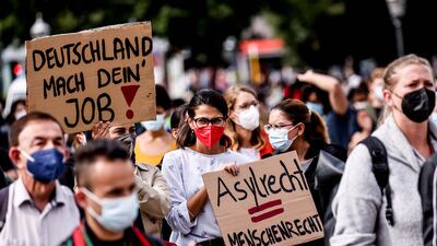 Protesters hold placards supporting asylum for Afghans during a rally in Berlin, Germany. EPA