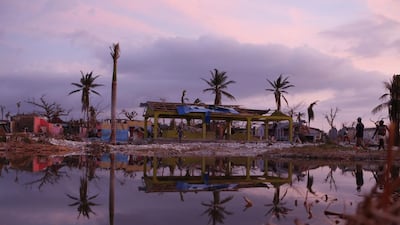 People walk past damaged buildings in a seaside fishing neighborhood almost completely destroyed by Hurricane Matthew in Port Salut, Haiti. Rebecca Blackwell / AP
