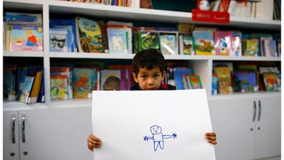 Syrian refugee Gays Cardak, 6, who holds his drawing in a school library in Yayladagi refugee camp in Hatay province near the Turkish-Syrian border, Turkey. “I’m going to be a doctor and an engineer. We the engineers will rebuild Syria, and I’ll take the (soldiers) to hospital,” Cardak said.