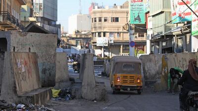 A tuk-tuk drives through a barricade at Al Rashid street in the Iraqi capital Baghdad amid ongoing anti-government demonstrations. AFP