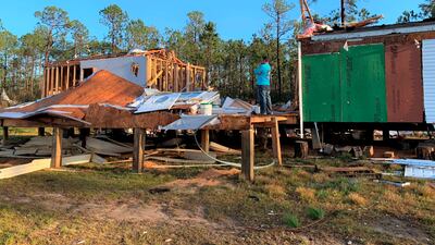 A homeowner stands in the middle of his trailer home cut in half by a tornado that touched down on Wednesday, in Vancleave, Mississippi. The Sun Herald / AP