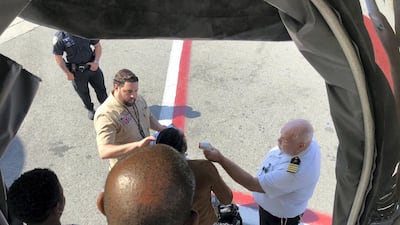 A passenger has her temperature taken as she leaves Emirates flight 203 at New York's John F Kennedy Airport. Larry Coben via AP